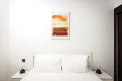 a bedroom with a white bed with a painting above it at Beautiful & Bright 2BR + kids - 7min to Dubai Mall in Dubai