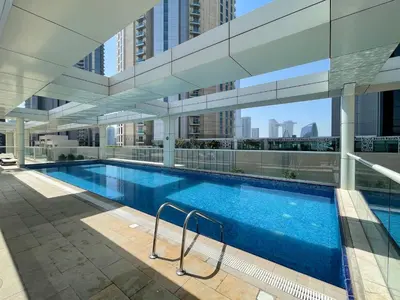a swimming pool with a view of a building at Beautiful & Bright 2BR + kids - 7min to Dubai Mall in Dubai