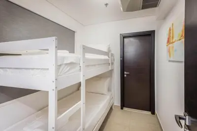 a bedroom with two bunk beds and a door at Beautiful & Bright 2BR + kids - 7min to Dubai Mall in Dubai