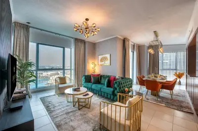 a living room with a green couch and a table at Durrani Homes - Luxe Living with Burj Khalifa and Fountain View - third room without partition in Dubai
