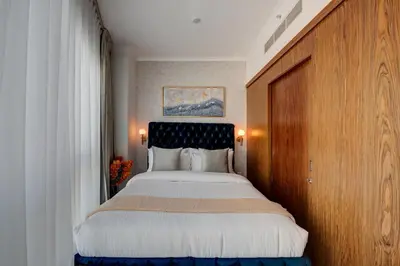 a bedroom with a large bed with a wooden headboard at Durrani Homes - Luxe Living with Burj Khalifa and Fountain View - third room without partition in Dubai