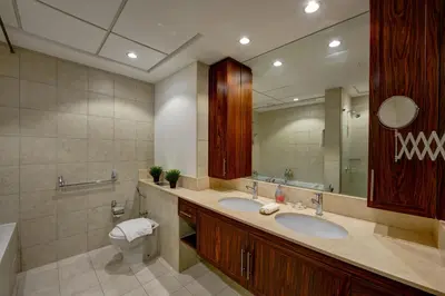a bathroom with two sinks and a toilet and a mirror at Durrani Homes - Luxe Living with Burj Khalifa and Fountain View - third room without partition in Dubai