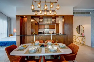 a dining room with a table and chairs and a bed at Durrani Homes - Luxe Living with Burj Khalifa and Fountain View - third room without partition in Dubai