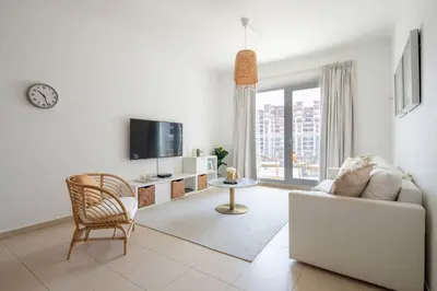 a living room with a white couch and a tv at Frank Porter - Grand Horizon in Dubai