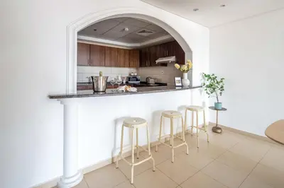 a kitchen with a counter and stools in a room at Frank Porter - Grand Horizon in Dubai