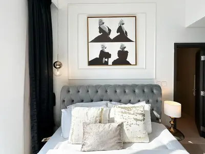 a bedroom with a bed with a picture above it at Stylish 2 Bedroom Dior-Inspired Apartment Connected to Dubai Mall in Dubai