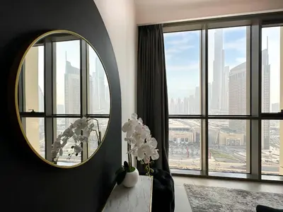 a round mirror in a room with a large window at Stylish 2 Bedroom Dior-Inspired Apartment Connected to Dubai Mall in Dubai