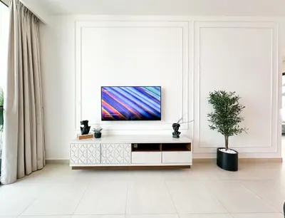 a living room with a tv on a white cabinet at Stylish 2 Bedroom Dior-Inspired Apartment Connected to Dubai Mall in Dubai