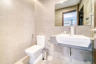 a bathroom with a white toilet and a sink at Deal of the Week Stylish 1BR with Partial Burj Views by Deluxe Holiday Homes in Dubai