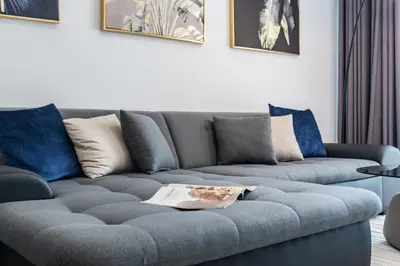 a living room with a gray couch with blue pillows at GlobalStay Royal Bay Beachfront Apartments Palm Jumeirah in Dubai