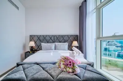 a bedroom with a large bed with a large window at GlobalStay Royal Bay Beachfront Apartments Palm Jumeirah in Dubai
