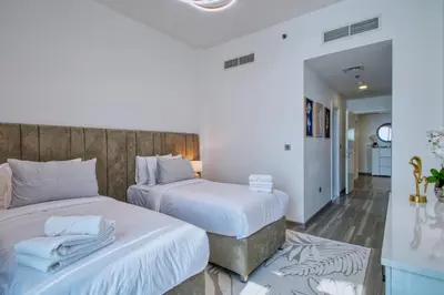 two beds in a room with white walls at GlobalStay Royal Bay Beachfront Apartments Palm Jumeirah in Dubai