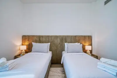two beds in a room with two lamps at GlobalStay Royal Bay Beachfront Apartments Palm Jumeirah in Dubai