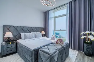 a bedroom with a large bed with a large window at GlobalStay Royal Bay Beachfront Apartments Palm Jumeirah in Dubai