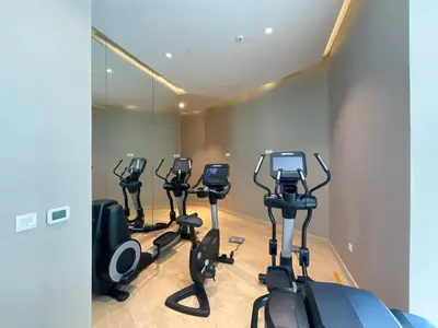 a row of exercise bikes in a fitness room at HiGuests - Roomy and Chic Studio with Panoramic Canal Views in Dubai