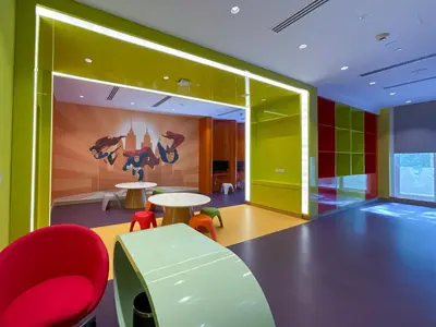 a room with a table and red chairs and a colorful wall at HiGuests - Roomy and Chic Studio with Panoramic Canal Views in Dubai