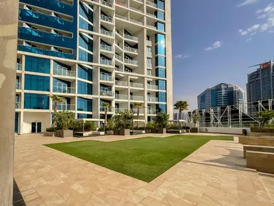 a large apartment building with a lawn in front of it at HiGuests - Roomy and Chic Studio with Panoramic Canal Views in Dubai