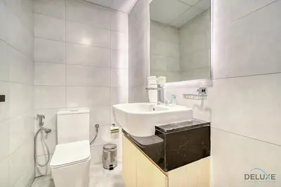 a white bathroom with a sink and a toilet at Prime 1BR at Binghatti Avenue Al Jaddaf by Deluxe Holiday Homes in Dubai