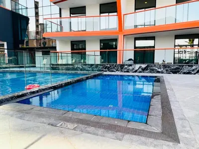 a swimming pool in front of a building at Prime 1BR at Binghatti Avenue Al Jaddaf by Deluxe Holiday Homes in Dubai