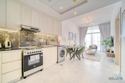 a kitchen with a stove and a dining room at Prime 1BR at Binghatti Avenue Al Jaddaf by Deluxe Holiday Homes in Dubai