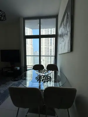 a dining room with a glass table and chairs and a window at Dubai Marina Royal Premium Serviced Apartments Marina Wharf - KIDS STAY FREE plus free check in 24 hours in Dubai