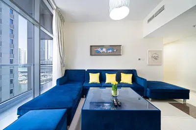 a living room with a blue couch and a table at Dubai Marina Royal Premium Serviced Apartments Marina Wharf - KIDS STAY FREE plus free check in 24 hours in Dubai