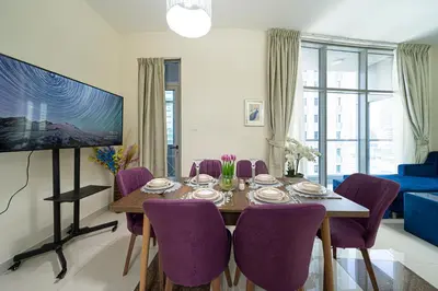 a dining room with a table and purple chairs at Dubai Marina Royal Premium Serviced Apartments Marina Wharf - KIDS STAY FREE plus free check in 24 hours in Dubai