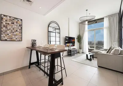a living room with a table and a couch at First Class Apartments in Dubai Hills - Next to Dubai Hills Mall - Socio, Collective and Golfville Towers in Dubai