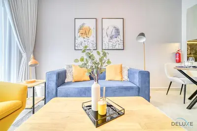 a living room with a blue couch and a table at Harmonious 1BR at Binghatti Avenue Al Jaddaf by Deluxe Holiday Homes in Dubai