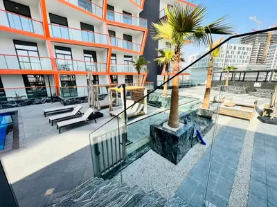 a balcony of a building with a palm tree and stairs at Harmonious 1BR at Binghatti Avenue Al Jaddaf by Deluxe Holiday Homes in Dubai