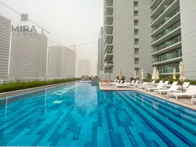 a swimming pool with chairs and a building at Mira Holiday Homes - Newly furnished 1 bedroom in Business Bay in Dubai