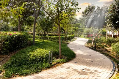 a walkway in a park with trees and flowers at STAY BY LATINEM Luxury 1BR Holiday Home CV A107 near Burj Khalifa in Dubai