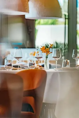a table with wine glasses and a vase of flowers at Radisson Beach Resort Palm Jumeirah in Dubai