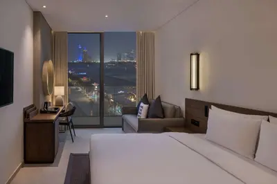 a hotel room with a bed and a large window at Radisson Beach Resort Palm Jumeirah in Dubai