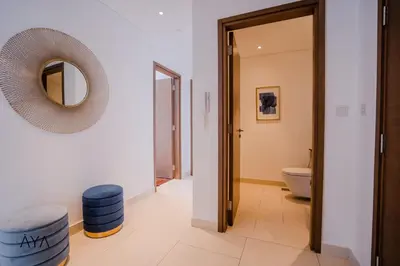 a bathroom with a mirror and two blue stools at Luxury Apartment with Pool, Patio & Gym in City Walk By ĀYA Boutique in Dubai