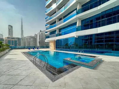 a swimming pool in front of a building at The Smart Concierge - Waves by Kasco in Dubai