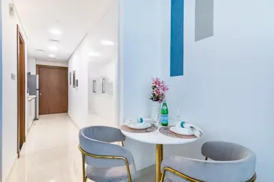 a dining room with a table and two chairs at The Smart Concierge - Waves by Kasco in Dubai