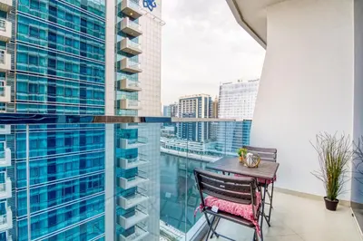 a balcony with a table and a view of the city at The Smart Concierge - Waves by Kasco in Dubai