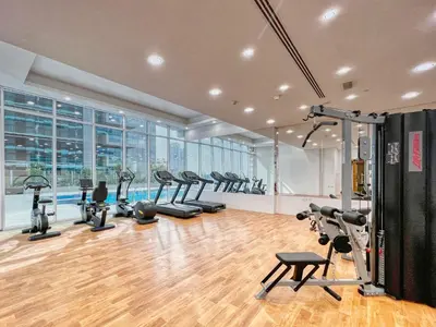a gym with a bunch of treadmills and exercise bikes at The Smart Concierge - Waves by Kasco in Dubai