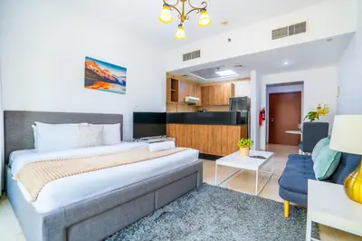 a bedroom with a large bed and a living room at RH- Chic & Sleek Studio apartment, near Burj Khalifa in Dubai