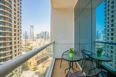 a balcony with two tables and chairs on a building at RH- Chic & Sleek Studio apartment, near Burj Khalifa in Dubai