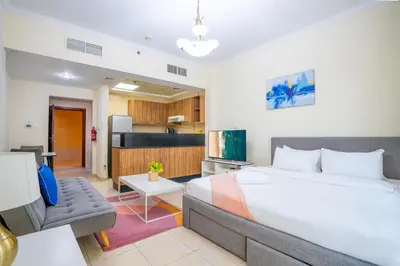 a bedroom with a large bed and a couch at RH- Contemporary Studio, Downtown, Near Dubai Mall & Burj Khalifa in Dubai