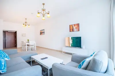 a living room with blue couches and a tv at RH- Modern Elegance 2BR, prime location, Walk to Dubai Mall in Dubai