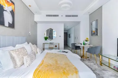 a bedroom with a large bed and a table at The Smart Concierge - Waves By KASCO in Dubai
