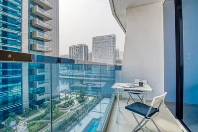 a balcony with a desk and chair on a building at The Smart Concierge - Waves By KASCO in Dubai