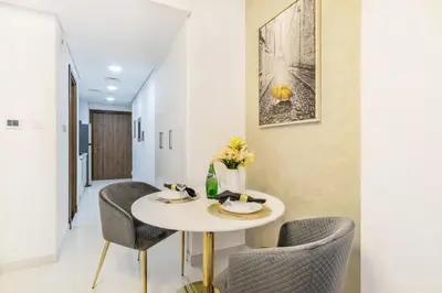 a dining room with a white table and chairs at The Smart Concierge - Waves By KASCO in Dubai