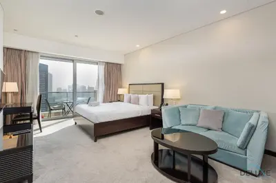 a hotel room with a bed and a couch at Marina Canal Views Next to Mall & Marina Promenade Studio Unit, The Address Residences, Dubai Marina by Deluxe Holiday Homes in Dubai