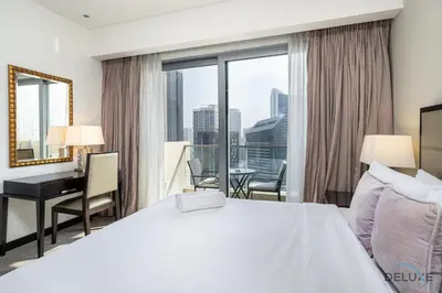 a hotel room with a bed and a desk and a window at Marina Canal Views Next to Mall & Marina Promenade Studio Unit, The Address Residences, Dubai Marina by Deluxe Holiday Homes in Dubai