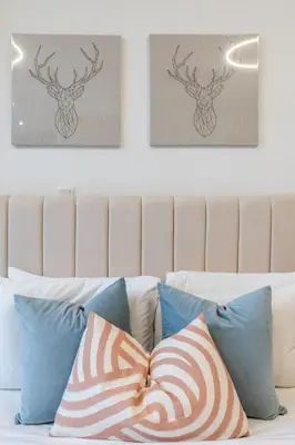a bed with pillows and two pictures on the wall at GuestReady - Zen in the heart of JVC in Dubai