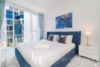a bedroom with a large bed with a large window at LUX The Pad Executive Suite Canal View 4 in Dubai